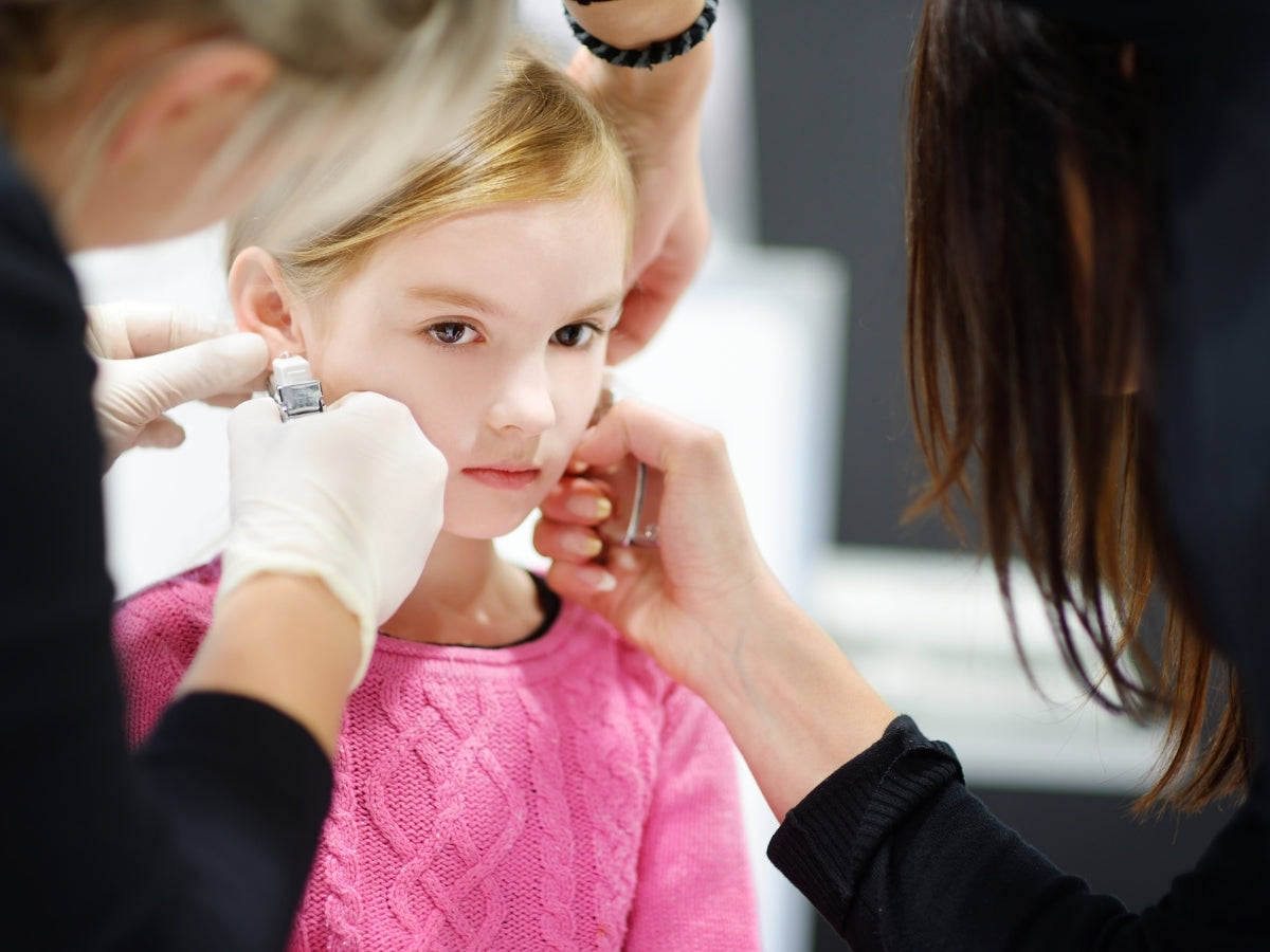 Child getting ear piercing at clinic