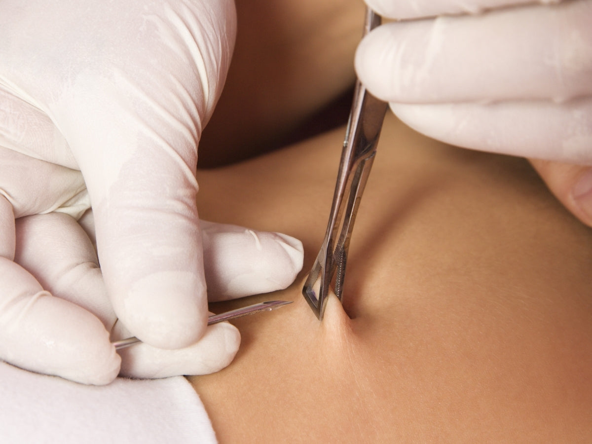 Professional body piercing needle procedure close-up